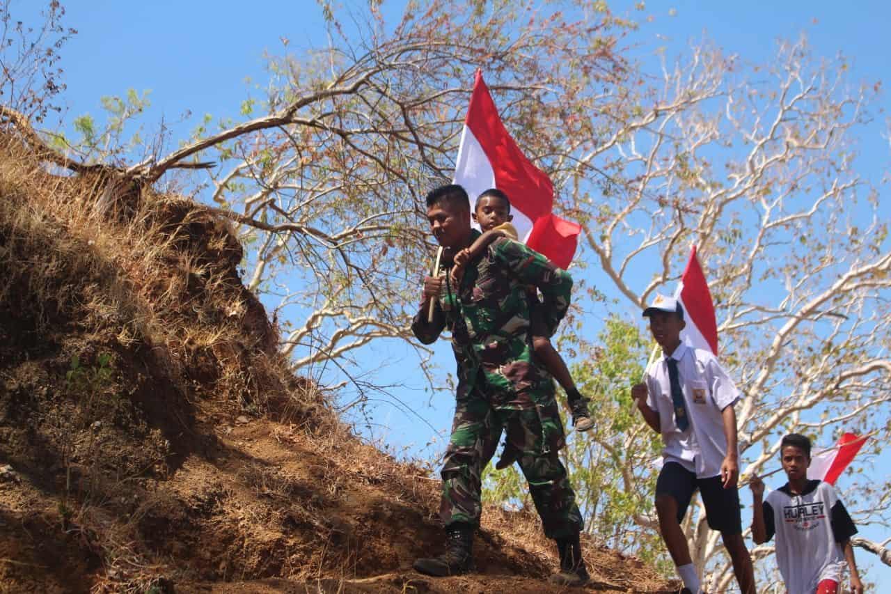 HUT Ke-74 TNI, Satgas Yonif R 142 dan Warga Kibarkan Merah Putih di Ketinggian 857 Mdpl