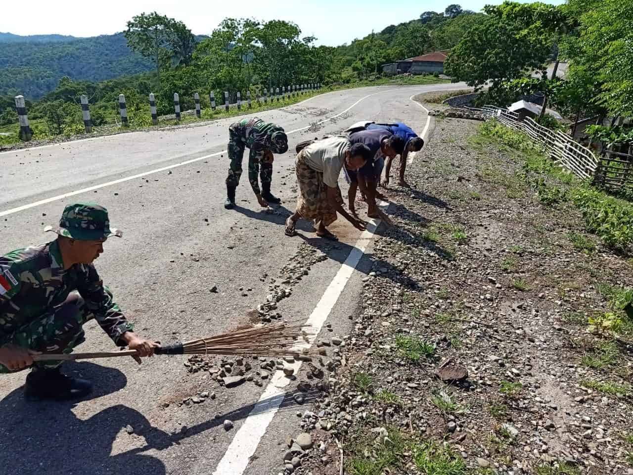 Cegah Kecelakaan, Satgas Yonif 142/ Bersihkan Kerikil Berserakan di Jalan