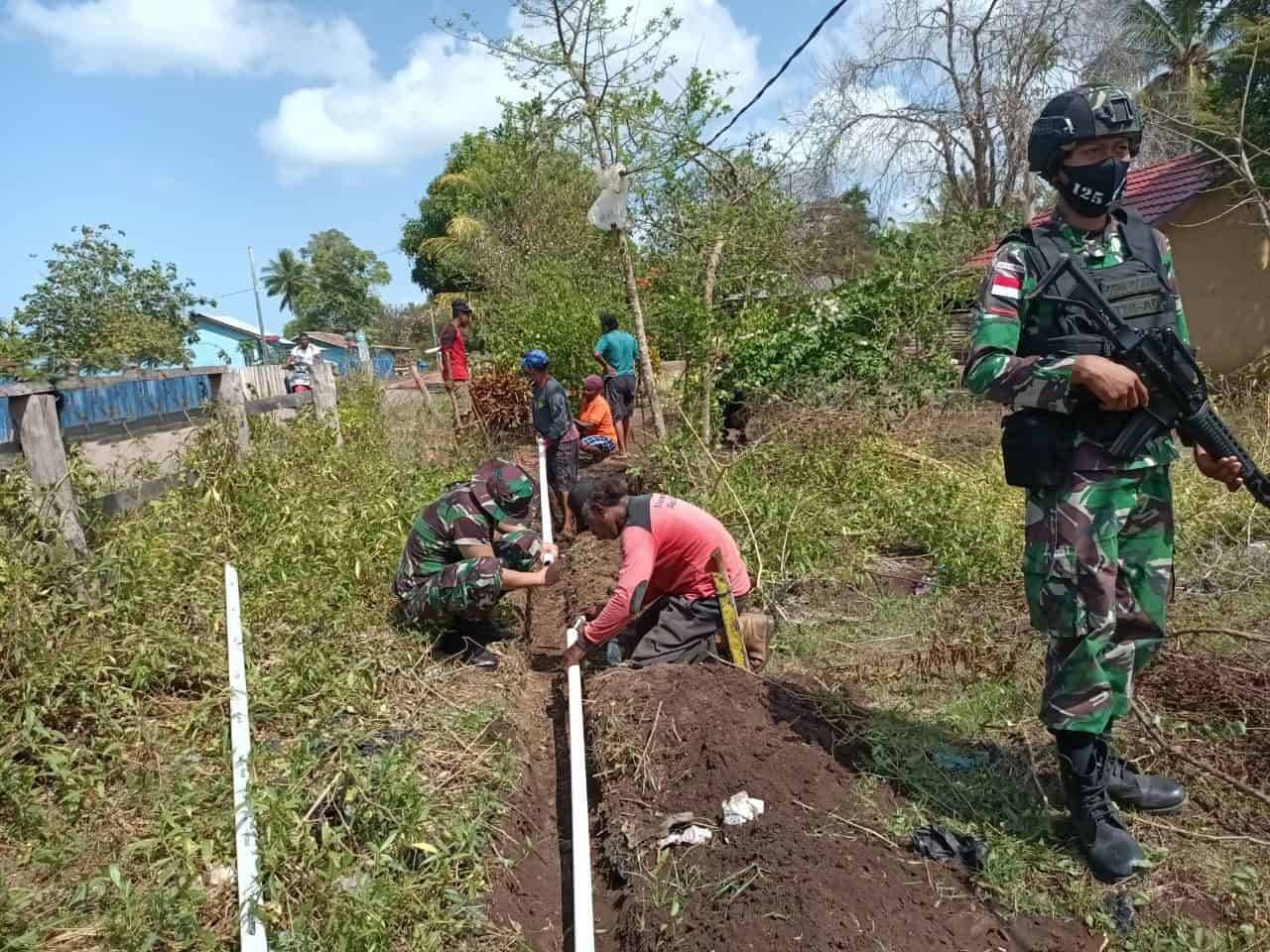 Prajurit Satgas Pamtas Yonif 125/Si’mbisa Berama Warga Kampung Kuler Pasang Pipa Saluran Air Bersih