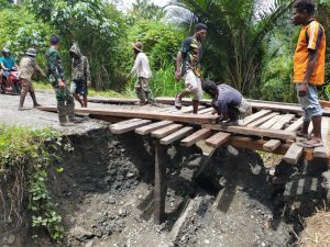 Satgas Yonif 403/WP Bersama Warga Bangun Jembatan Kayu di Jalur Trans Papua Pasca Longsor