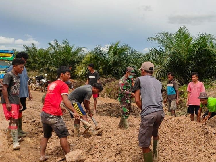 Babinsa Muntai dan Warga Gotong Royong Timbun Jalan Rusak