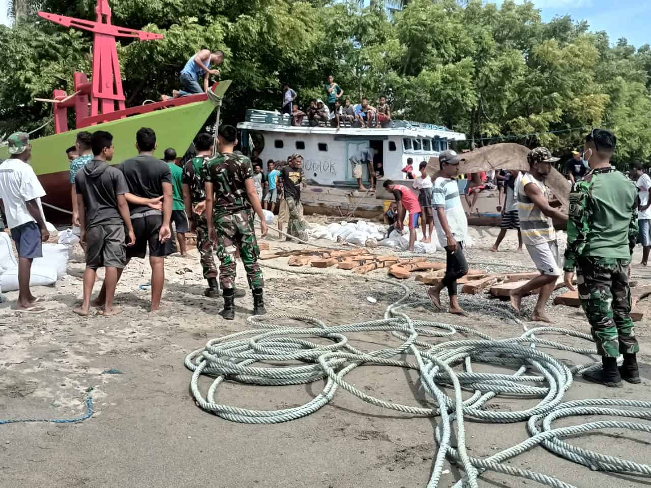 Gotong Royong, Satgas Yonarmed 6/3 Bersama Warga Turunkan Kapal Ke Pantai