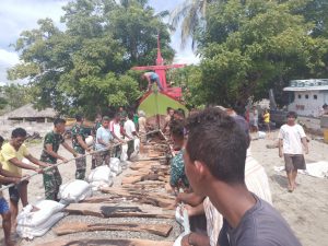 Gotong Royong, Satgas Yonarmed 6/3 Bersama Warga Turunkan Kapal Ke Pantai