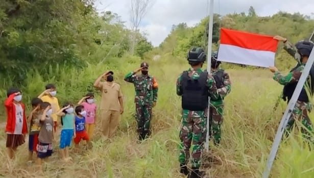 Sambut HUT RI, Satgas Yonif 144/JY Bersama Warga Pasang Bendera di Depan Rumah Panjang