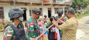 Sambut HUT RI, Satgas Yonif 144/JY Bersama Warga Pasang Bendera di Depan Rumah Panjang