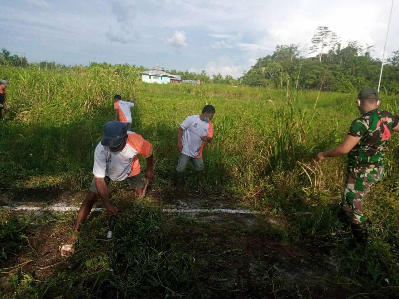 Satgas Yonif 131 Bersama Warga Gotong Royong Bersihkan Lapangan Kampung Pitewi