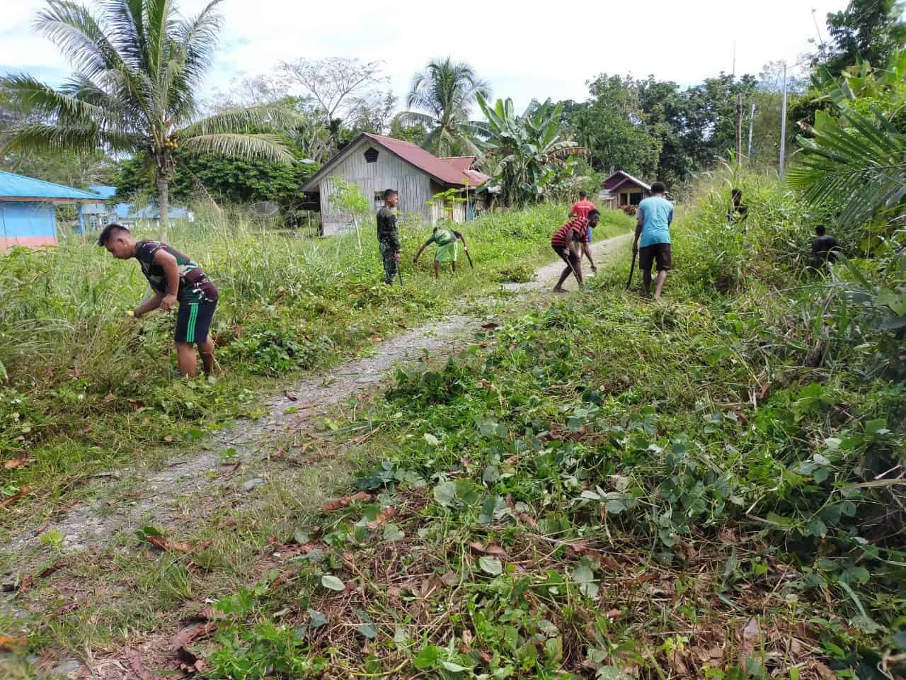 Satgas Yonmek 403 Bersama Warga Bersihkan Jalan Masuk SMP di Kampung Bompay