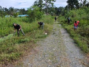 Satgas Yonmek 403 Bersama Warga Bersihkan Jalan Masuk SMP di Kampung Bompay