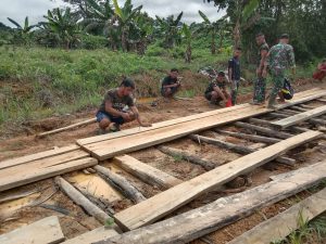 Personel Satgas Pamtas Yonif 144/JY Bersama Warga Gotong Royong Perbaiki Jalan Desa Di Perbatasan