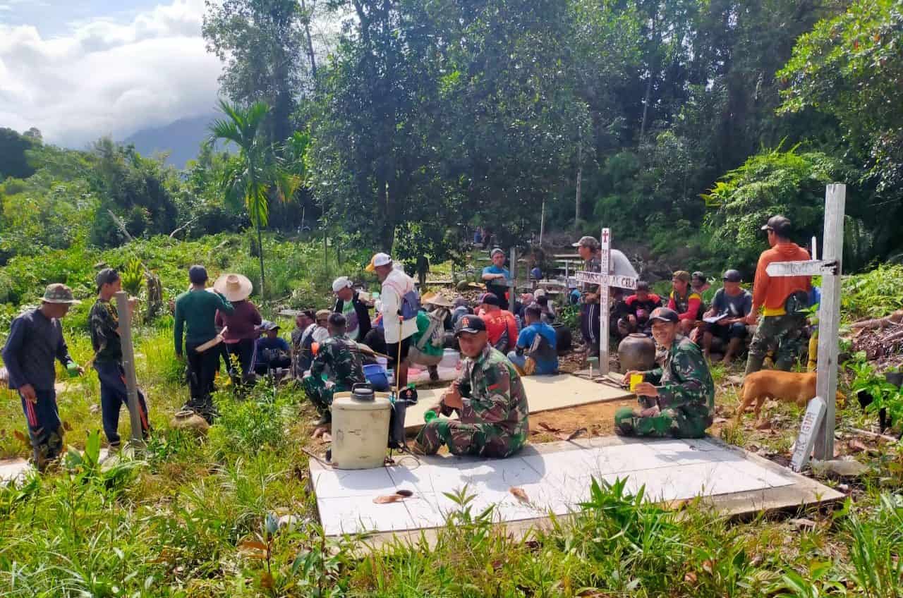 Jelang Natal Anggota Satgas Yonif 144/JY Gotong Royong Bersihkan Makam Bersama Warga Perbatasan