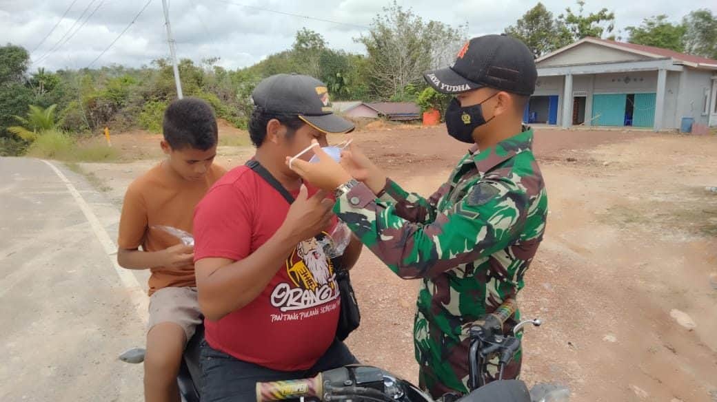 Sinergitas Anggota Satgas Yonif 144/JY Bersama Polri Bagikan Masker Warga di Perbatasan