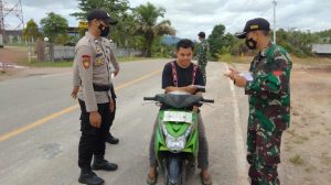 Sinergitas Anggota Satgas Yonif 144/JY Bersama Polri Bagikan Masker Warga di Perbatasan