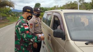 Sinergitas Anggota Satgas Yonif 144/JY Bersama Polri Bagikan Masker Warga di Perbatasan