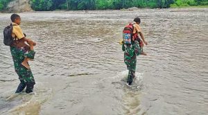 Sungai Talau Meluap, Satgas Yonif 743/PSY Bantu Seberangkan Anak Sekolah