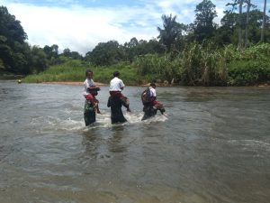 Anggota Satgas Yonif 144/JY Bantu Seberangkan Siswa Sekolah di Sungai Perbatasan
