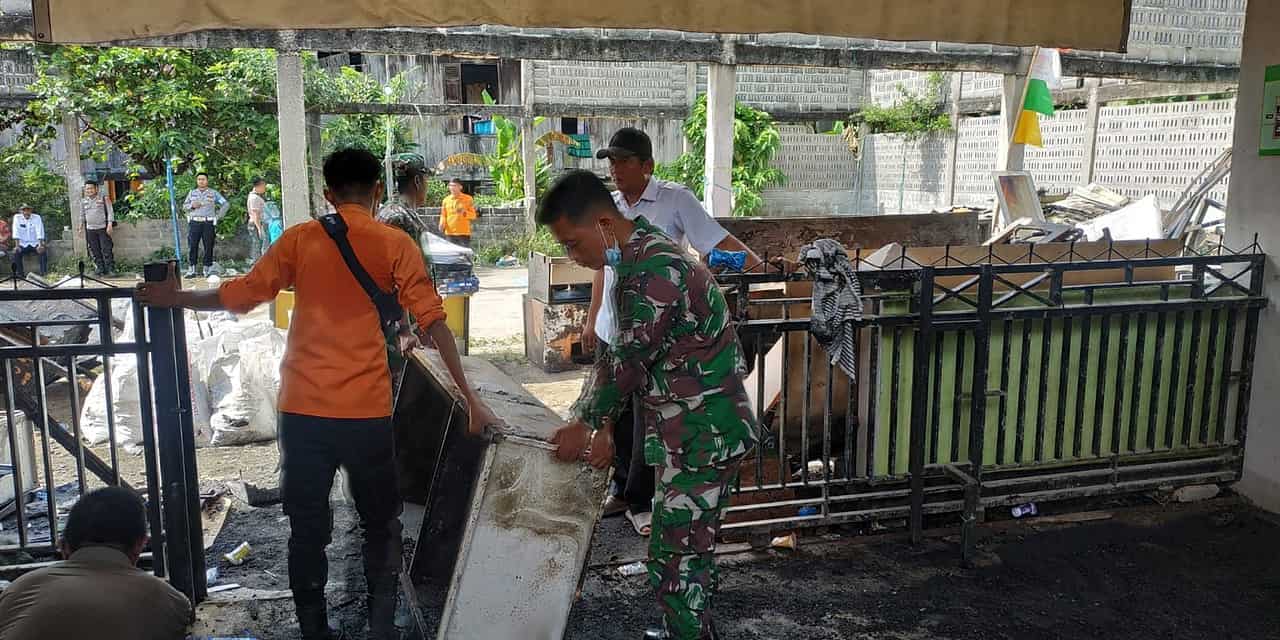 Babinsa Koramil 402-04/Tanjung Raja Bersihkan Puing Kebakaran Puskesmas Rantau Panjang