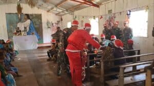 Berpakaian Santa Claus, Personel Satgas Yonif R 303/SSM Bagikan Kado Natal