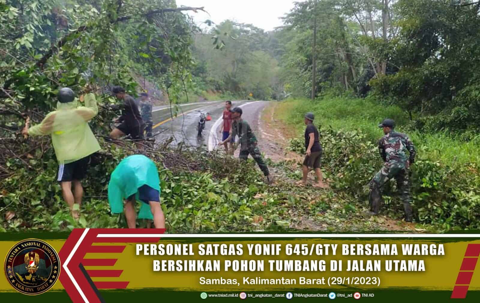 Personel Satgas Yonif 645/GTY Bersama Warga Bersihkan Pohon Tumbang di Jalan Utama