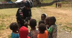 Satgas Yonif Raider 303 Kostrad Bagikan Anak – Anak Makanan dan Permen di Distrik Gome