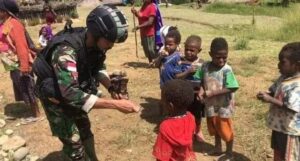 Satgas Yonif Raider 303 Kostrad Bagikan Anak – Anak Makanan dan Permen di Distrik Gome