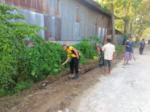 Prajurit Kodim 0418/Plg Gotong Royong Bersihkan Parit dana rumput Bersama Warga