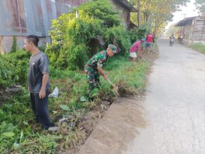 Prajurit Kodim 0418/Plg Gotong Royong Bersihkan Parit dana rumput Bersama Warga