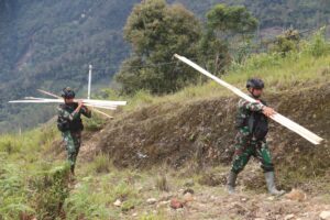 Panggul Papan Kayu Belasan Kilometer, Satgas Yonif 330 Bantu Bangun Honai Warga