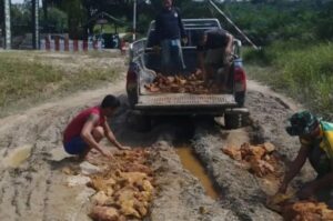 Satgas Yonarmed 10 Kostrad Bersama Warga Gotong Royong Perbaiki Jalan Rusak