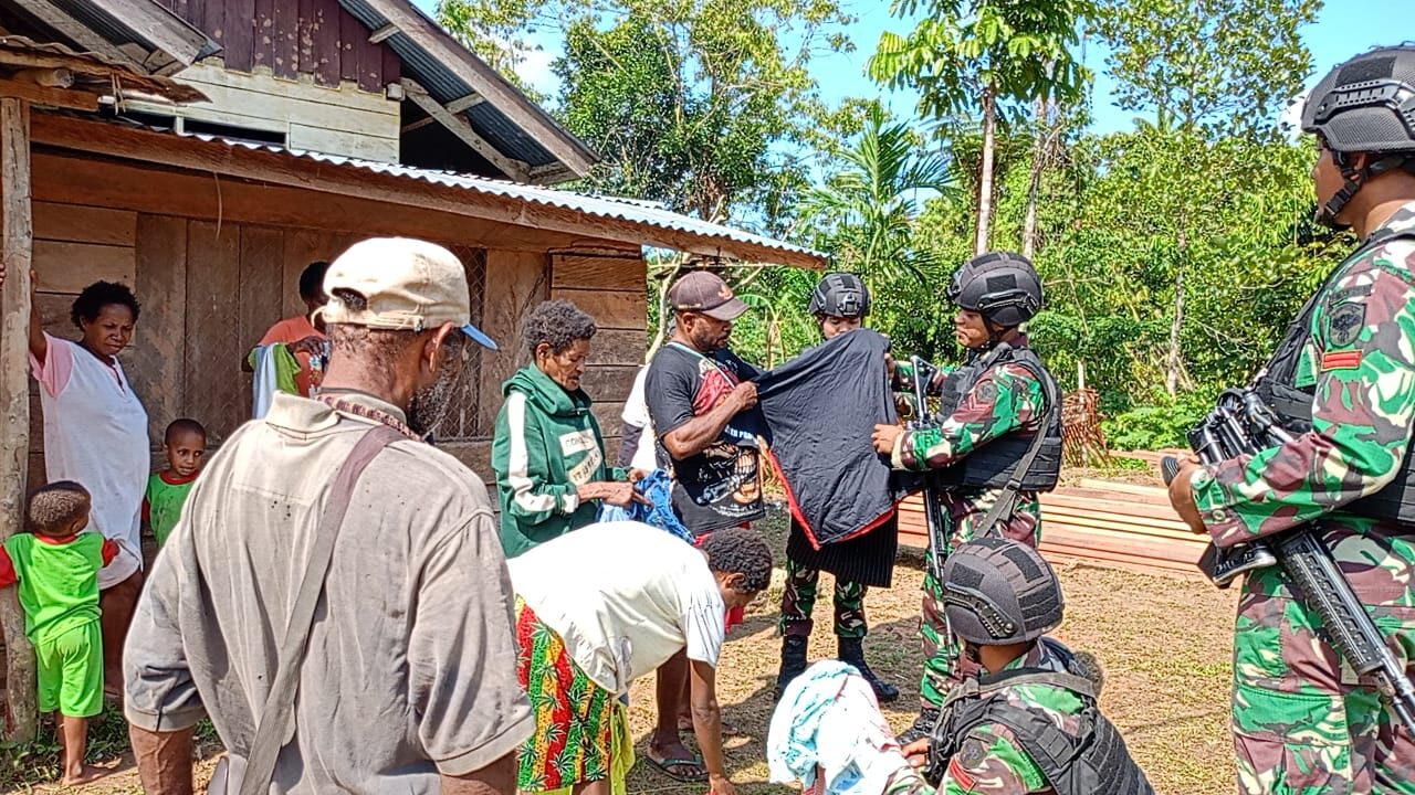 Masuk Kampung, Anggota Satgas Yonif 111/KB Dikerumuni Mama Papua Bagikan Pakaian