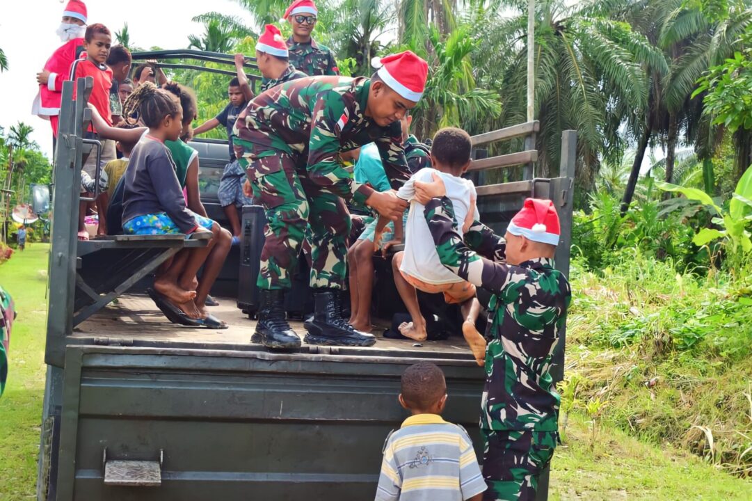 Satgas Yonif 122/TS Hadirkan Santa Claus dengan membagikan bingkisan makanan pada Karnaval menyambut perayaan Hari Raya Natal Penuh Kebahagiaan dan Kedamaian